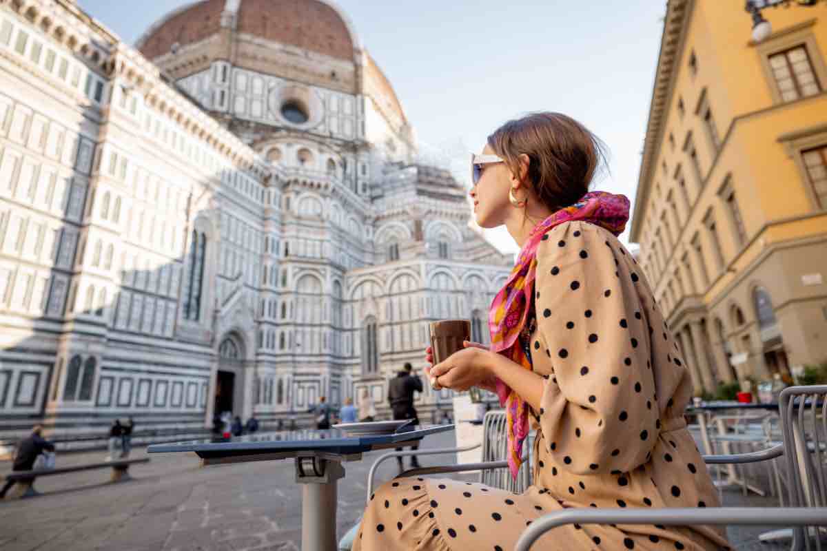 Una donna beve un caffè vicino al Duomo di Firenze