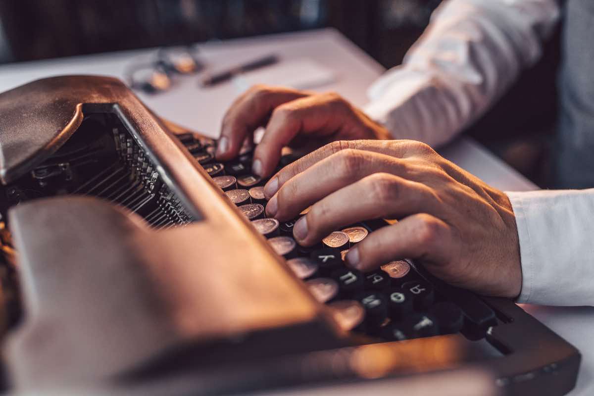 Un uomo che scrive con la macchina da scrivere